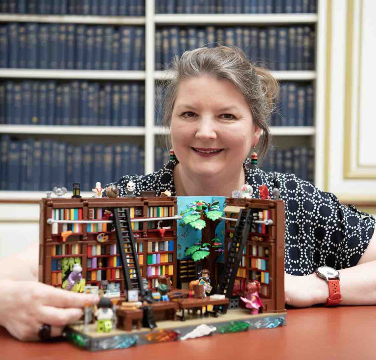 Teresa Elsmore with a fantastical lego library model which forms part of the National Library of Scotland's centenary exhibition 'Dear Library'