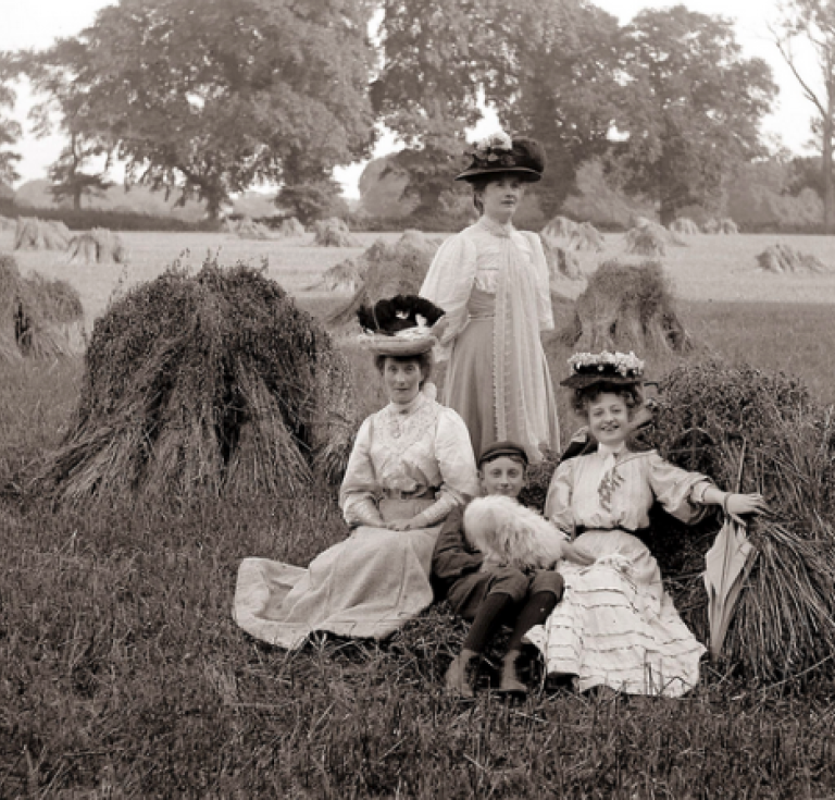 Photographic image of three women and a boy in a wheatfield.